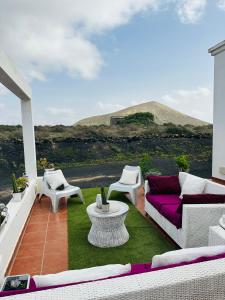a patio with a purple couch and a table and chairs at Habitación Dache Lanzarote in Tías