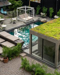 a backyard with a swimming pool with a grass roof at Bryggen Guldsmeden in Copenhagen