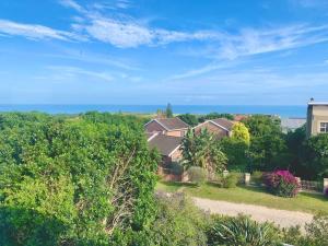 una vista aérea de una casa con árboles y el océano en Bromley loft en Port Alfred