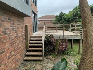 una escalera de madera junto a un edificio de ladrillo en Bromley loft, en Port Alfred