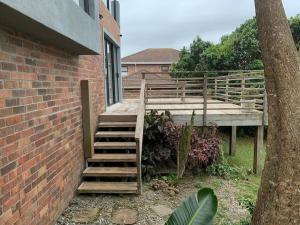 a wooden staircase next to a brick building at Bromley loft in Port Alfred