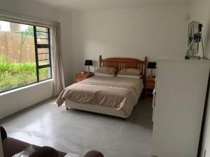 a bedroom with a bed and a large window at Bromley loft in Port Alfred