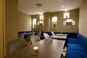 SuMa Recoleta Hotel في بوينس آيرس: غرفة طعام مع طاولات وكراسي وأضواء