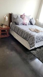 a bedroom with a bed with pillows and a table at Gorgeous in Johannesburg