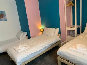 two twin beds in a room with blue and pink walls at The Royal Clarence Hotel (on the Seafront) in Burnham on Sea