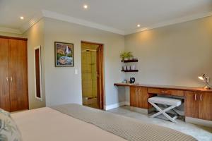 a bedroom with a bed and a desk in it at Thanda Manzi Country Hotel in Centurion