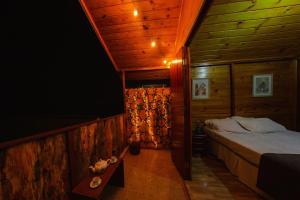 カンポス・ド・ジョルドンにあるCabanas Capivari Lodgeのベッドルーム(ベッド1台、テレビ付)
