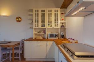 a kitchen with white cabinets and a table at Agriturismo Primaluna in Castenaso