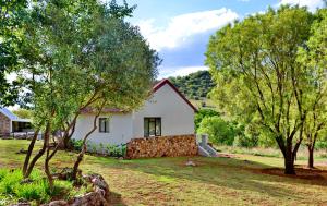 a white house with trees in front of it at Thanda Manzi Country Hotel in Centurion