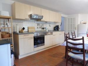 a kitchen with white cabinets and a stove top oven at Reetgedecktes Ferienhaus Ulrichshorst in Ulrichshorst