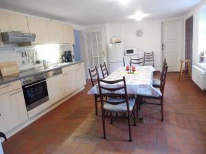 a kitchen with a table and chairs in a kitchen at Reetgedecktes Ferienhaus Ulrichshorst in Ulrichshorst