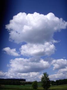 a large cloud in the sky over a green field at Golf-Appartement Sonnenblick in Neualbenreuth