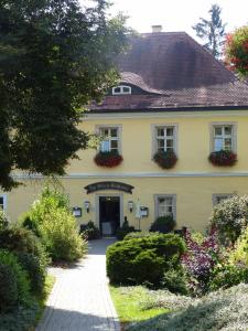 諾伊阿爾本羅伊特的住宿－Golf-Appartement Sonnenblick，一座黄色的大房子,窗户上有鲜花