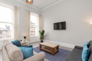 a living room with a couch and a table at Southside Apartments by Destination Edinburgh in Edinburgh