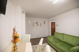 un soggiorno con divano verde e tavolo di Apartament Gold a Tîrgu Ocna