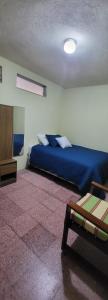 ein Schlafzimmer mit einem blauen Bett in einem Zimmer in der Unterkunft Casa para viajes de descanso o de negocios in Quetzaltenango