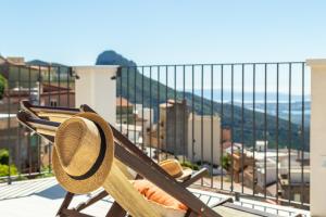 un cappello di paglia seduto su una sedia sul balcone di Monte Forru a Baunei