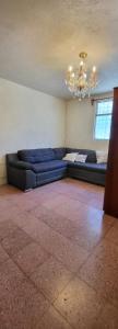 a living room with a blue couch and a chandelier at Casa para viajes de descanso o de negocios in Quetzaltenango