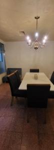 a dining room with a table and chairs and a chandelier at Casa para viajes de descanso o de negocios in Quetzaltenango