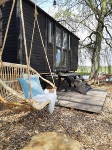 a hammock swing in front of a cabin at Tiny House met sauna, vrij uitzicht, midden in de natuur 