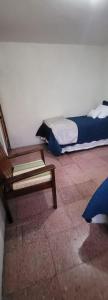 a room with two beds and a wooden bench at Casa para viajes de descanso o de negocios in Quetzaltenango
