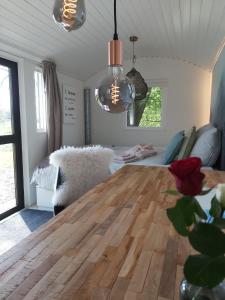 a dining room with a wooden table and a couch at Tiny House met sauna, vrij uitzicht, midden in de natuur 