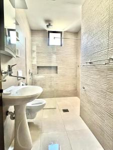 ein Badezimmer mit Waschbecken, Toilette und Dusche in der Unterkunft Adriatic Apartments in Ulcinj + 114 Fotos