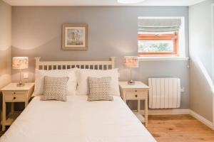 una camera da letto con un grande letto bianco con due comodini di The Shepherd's Rest a Thurso