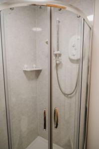 a shower with a glass door next to a toilet at The Shepherd's Rest in Thurso