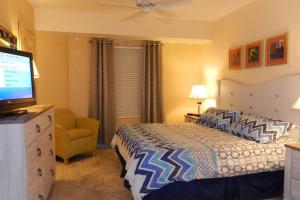 a bedroom with a bed and a flat screen tv at 6th Floor 1 BR Direct Oceanfront Condo Wyndham Ocean Walk - Daytona Funland 606 in Daytona Beach