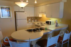 a kitchen with a sink and a table with chairs at 6th Floor 1 BR Direct Oceanfront Condo Wyndham Ocean Walk - Daytona Funland 606 in Daytona Beach