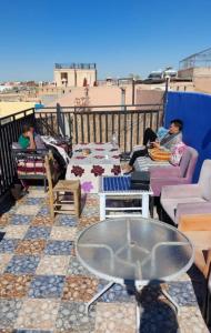 eine Gruppe von Personen, die auf einem Balkon sitzen in der Unterkunft Hostel Marrakech Rouge in Marrakesch