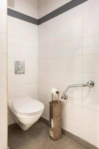 a bathroom with a toilet in a white tiled room at La Tour 1 Appartement au coeur du centre ville in LʼIsle-sur-la-Sorgue +9 photos