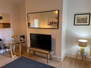 a living room with a large television and a table at Oakstays Forest Hall in Forest Hall