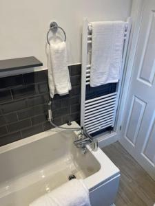 a bathroom with a tub and towels on a wall at Oakstays Forest Hall in Forest Hall