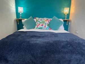 a blue bedroom with a large bed with pillows at Oakstays Forest Hall in Forest Hall