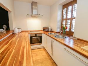 a kitchen with a wooden counter top and a sink at 14 Llewelyn Street in Conwy