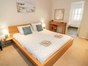 a bedroom with a large bed with two towels on it at 14 Llewelyn Street in Conwy
