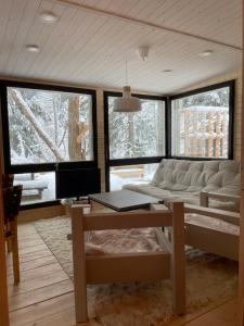 ein Wohnzimmer mit einem Sofa und einem Tisch in der Unterkunft Mokki kesämökki in Jyväskylä