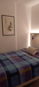 1 dormitorio con 1 cama con manta azul y amarilla en K&S 68 Appt Standing vue mer - Garage Inclus, en Roquebrune-Cap-Martin