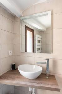 een badkamer met een witte wastafel en een spiegel bij Le marronnier 2 in LʼIsle-sur-la-Sorgue
