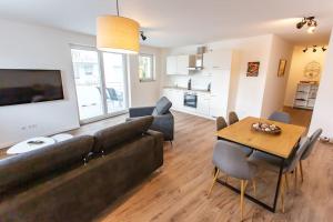 a living room with a couch and a table at Große COZY 4-Zi-Whg mit Balkon Nähe Europa Park und Rulantica in Lahr