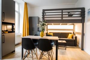 a dining room and living room with a loft bed at Homaris Boxi Studios in Berlin