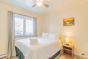a bedroom with a white bed with a window at Centrally Located Comfort And Coffee 3 in Fairbanks