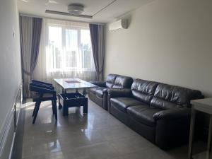 a living room with a leather couch and a table at Sun Lidia in Chernivtsi