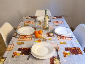 un tavolo con piatti bianchi e una bottiglia di vino di Apartamento Puig Campana a Benidorm