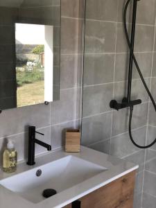 a bathroom sink with a shower and a mirror at Maison neuve spacieuse port et plages à pied in Ploudalmézeau