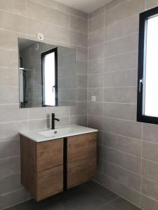 a bathroom with a sink and a mirror at Maison neuve spacieuse port et plages à pied in Ploudalmézeau