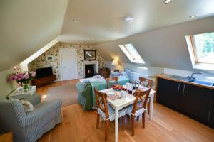 a kitchen and living room with a table and chairs at Stables Cottage in Stranraer