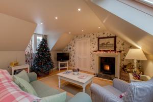 a living room with a christmas tree and a fireplace at Stables Cottage in Stranraer